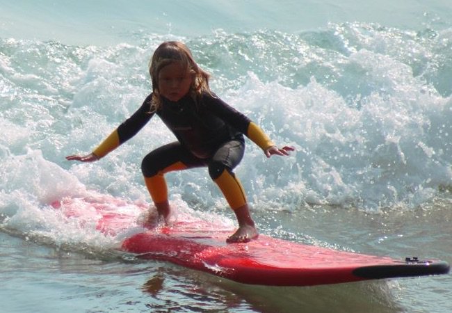 Small child surfing in 30A