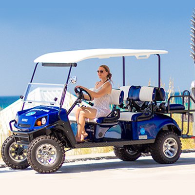 Woman riding a street legal golf cart near the beach