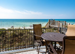 Table with chairs on deck by the boardwalk and beach